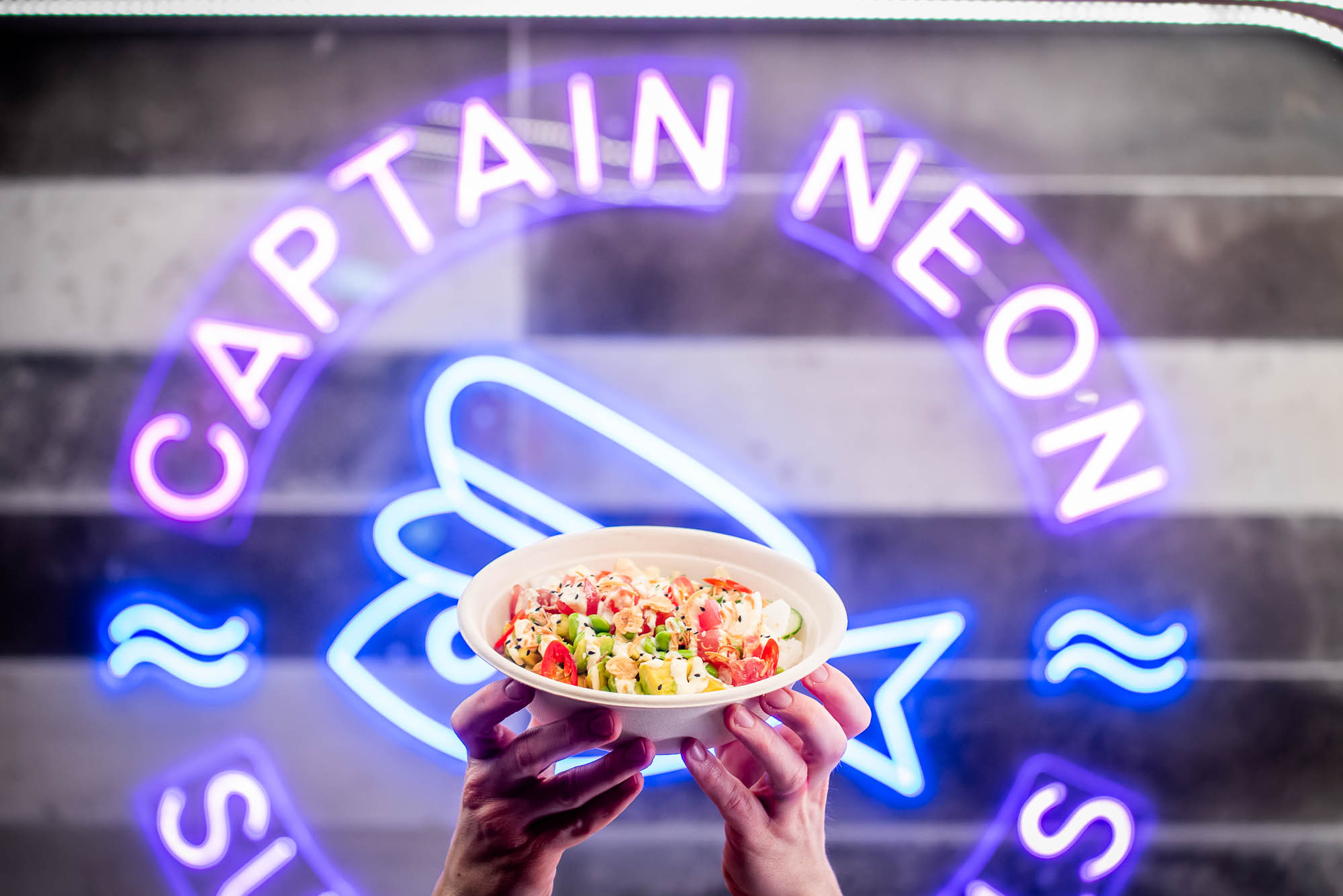 captain neon bowl in front of neon sign